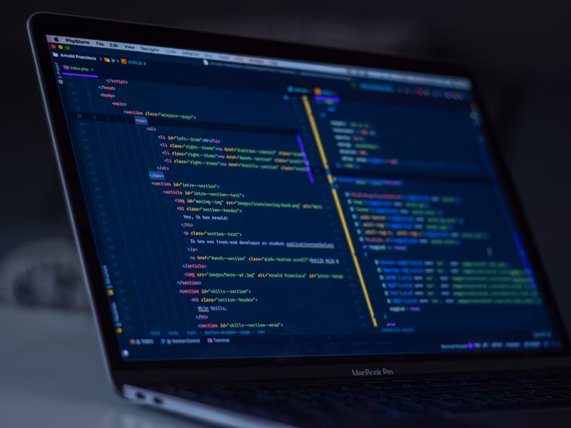Developer coding on laptop with colorful syntax highlighting